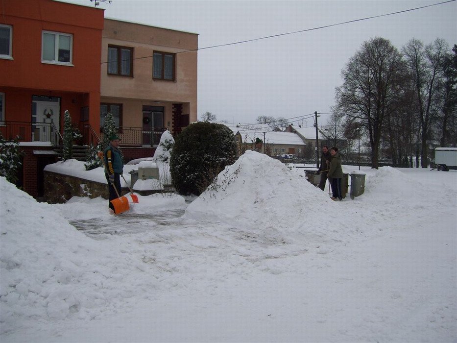 Hromady sněhu z chodníků před řadovkami: